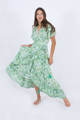 Our Palma high low summer dress, ties in the waist. It's in green color with a handprint floral pattern.