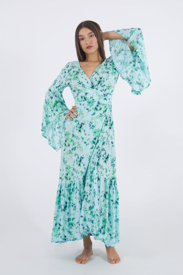 Model wearing our long floral dress with side wrap and trumpet sleeves.